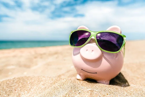 Piggy bank dengan kacamata hitam di pantai — Stok Foto