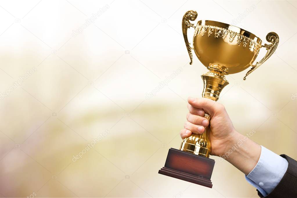 hand holding golden trophy