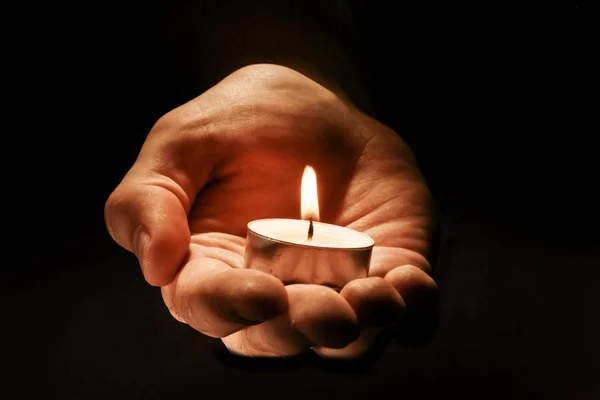 Burning candle in male hand — Stock Photo, Image