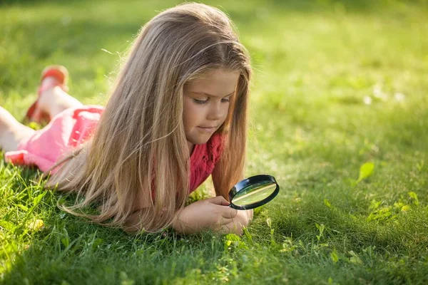 Menina usando vidro de ampliação — Fotografia de Stock