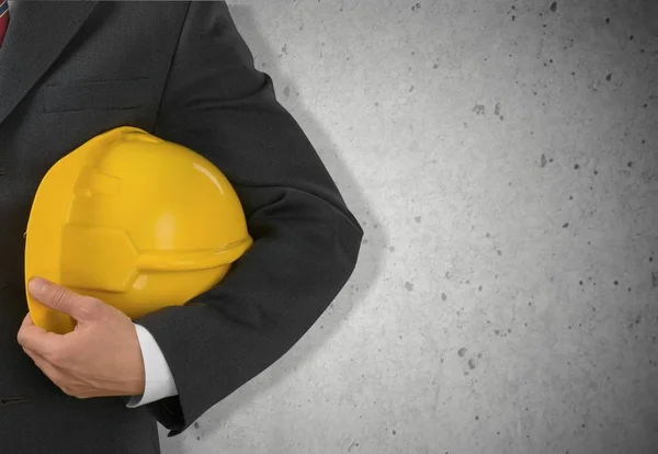 Empresario sosteniendo en la mano casco amarillo — Foto de Stock