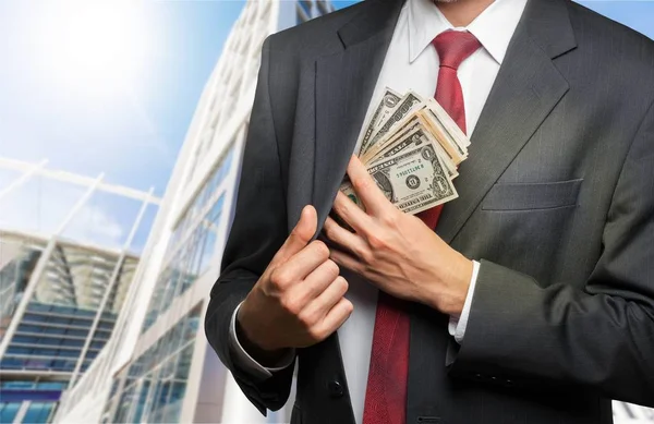 Бізнесмен розміщує гроші в кишеню — стокове фото