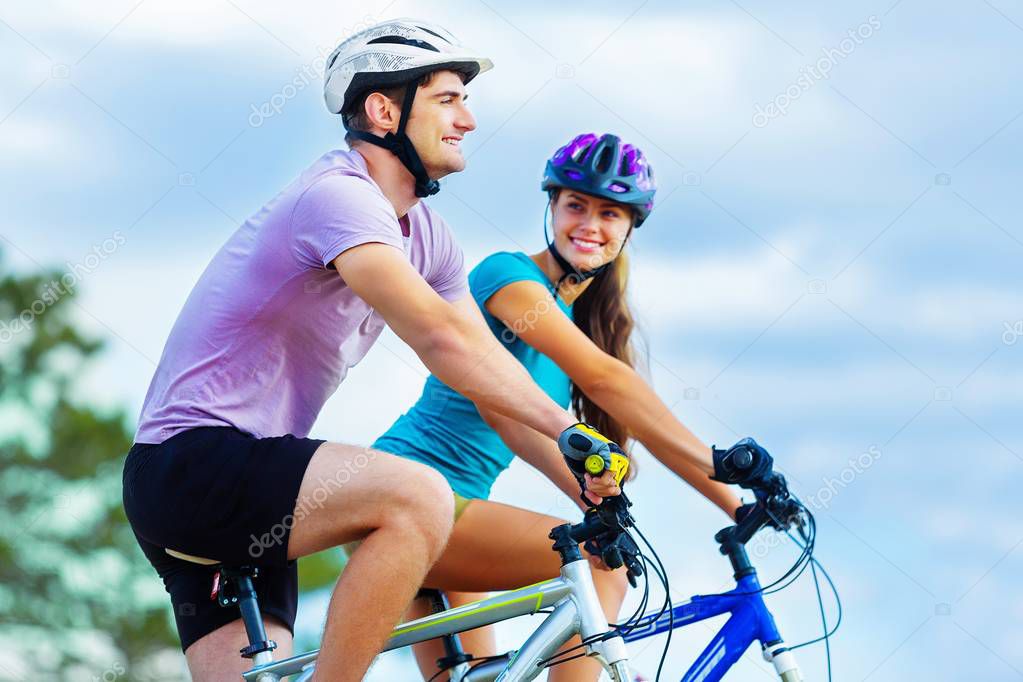  happy couple riding bicycle outdoors