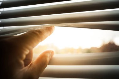 jalousie ile bakan kişinin kısmi görünümü