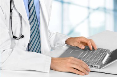Dizüstü bilgisayar üzerinde çalışan doktor
