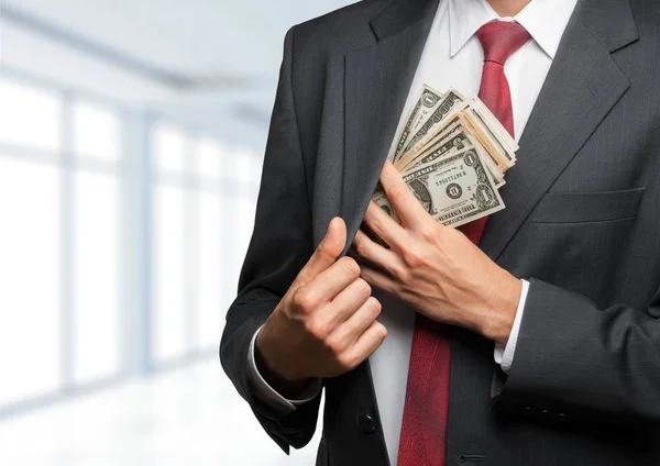 Empresário colocando dinheiro em seu bolso — Fotografia de Stock