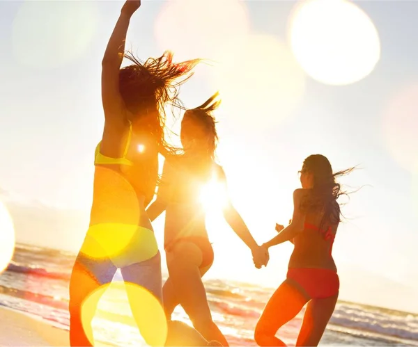 Mulheres jovens caminhando na costa do mar — Fotografia de Stock