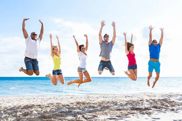 Friends jumping on beach — Zdjęcie stockowe