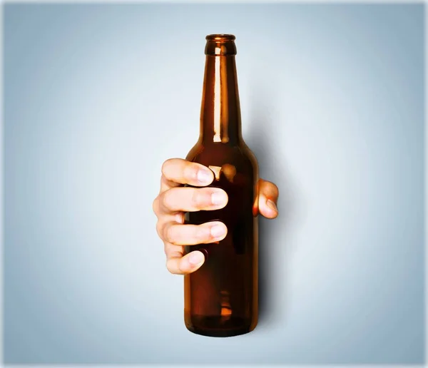 Mão segurando garrafa marrom — Fotografia de Stock
