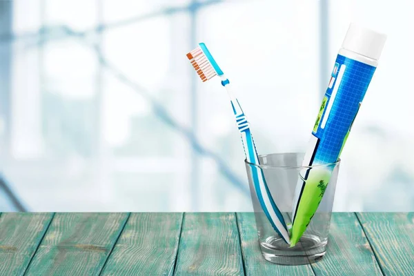 Toothbrushes and paste in glass — Stock Photo, Image