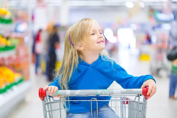 Girl in dress at shopping cart — Stock Photo, Image