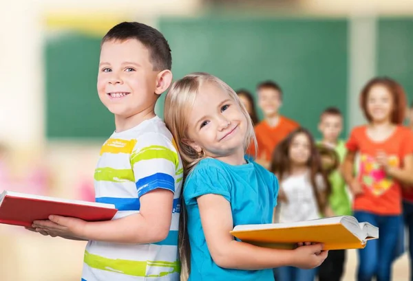 Ragazzo e ragazza in possesso di libri — Foto Stock