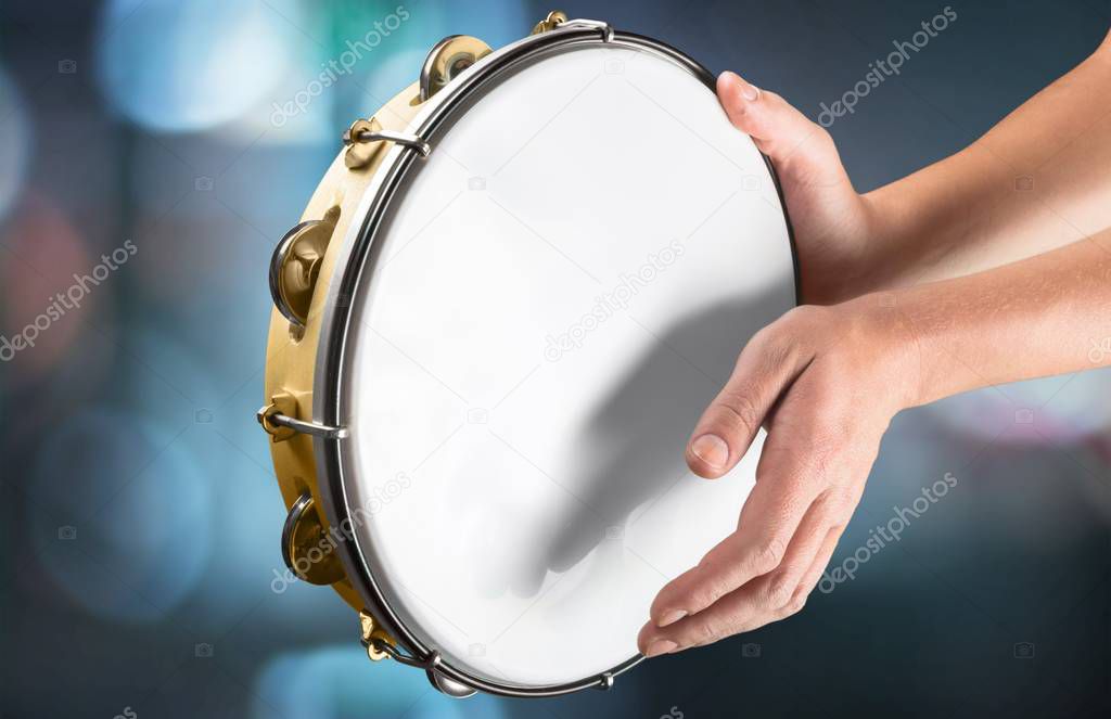 female hands Playing the tambourine