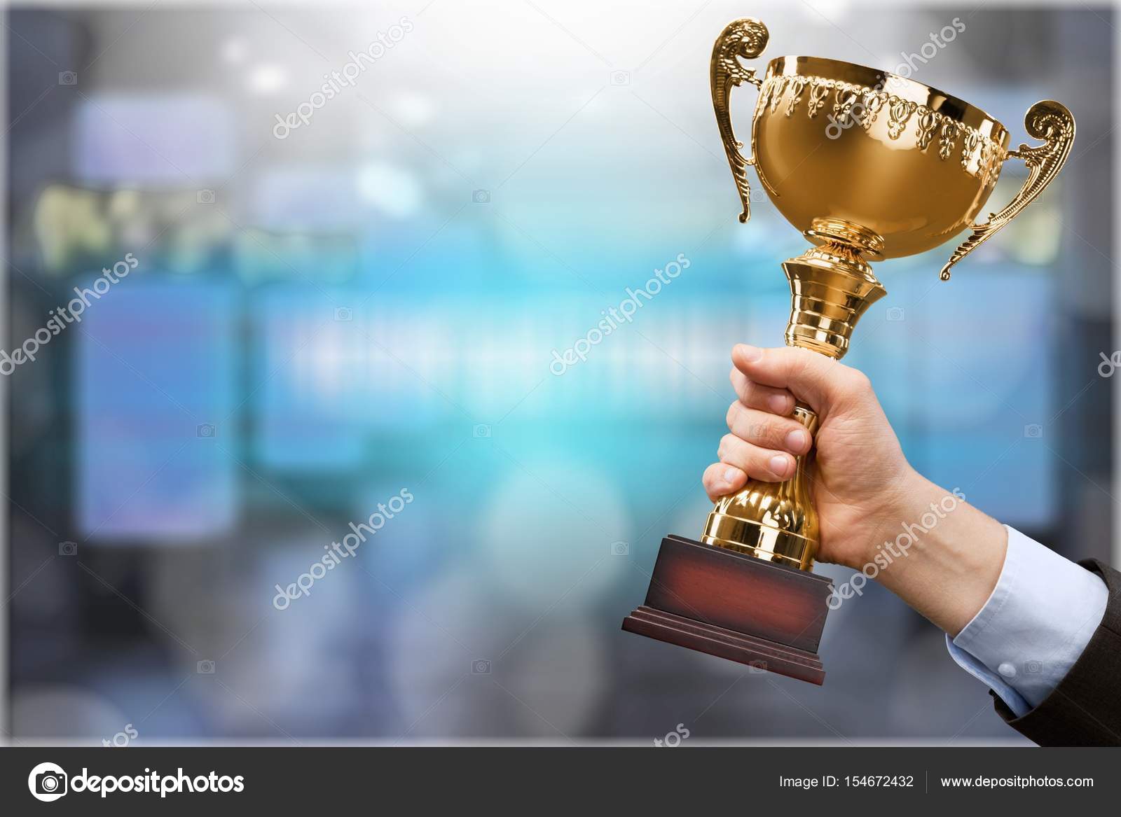 Hand holding golden Trophy Stock Photo by ©billiondigital 154672432