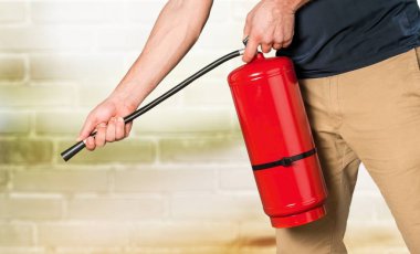 El tetik yangın söndürücüsüne basar.