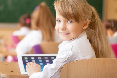 Tablet ile gülümseyen kız öğrenci