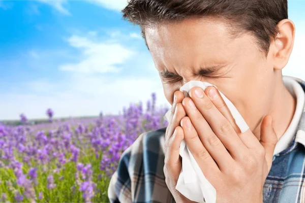 Handsome boy blowing his nose — Stock Photo, Image