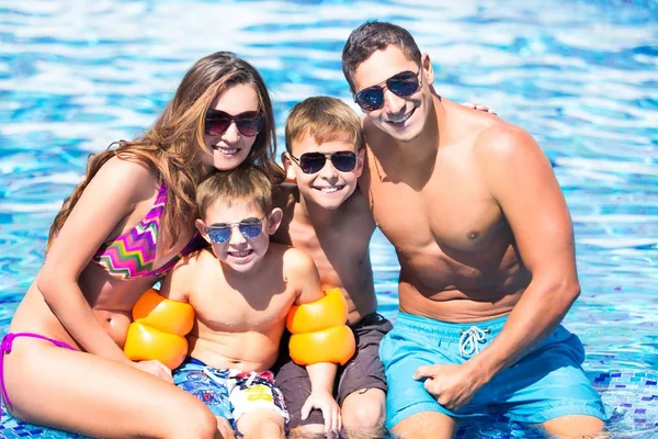Família feliz brincando na piscina. — Fotografia de Stock