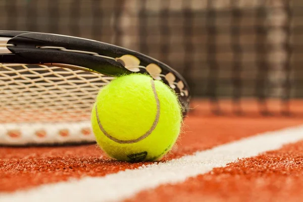 Tennis ball and racket on court — Stock Photo, Image