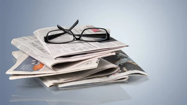 Stack of newspapers and eyeglasses — Stock Photo, Image