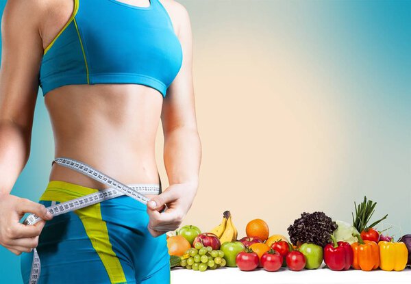 young woman measuring her thin waist 