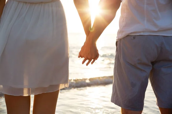 Koppel hand in hand op het strand — Stockfoto