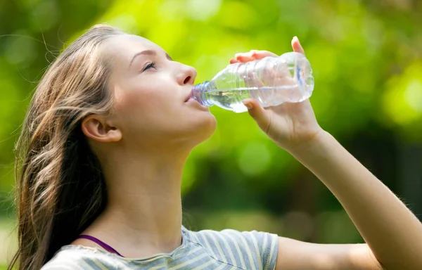 Giovane donna che beve acqua — Foto Stock