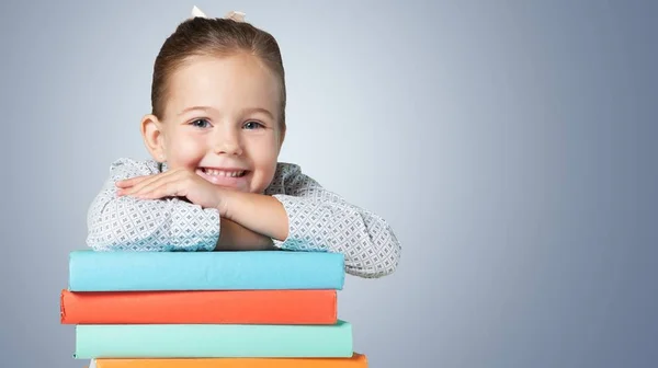Милая молодая девушка с стопкой книг — стоковое фото