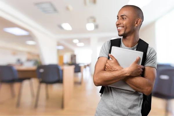 Étudiant tenant un cahier et sourire — Photo