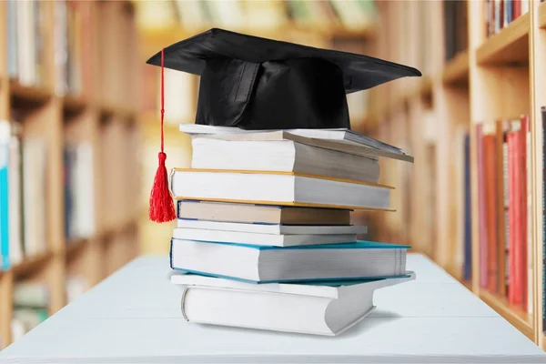 Graduation mortarboard on stack of books — Stock Photo, Image