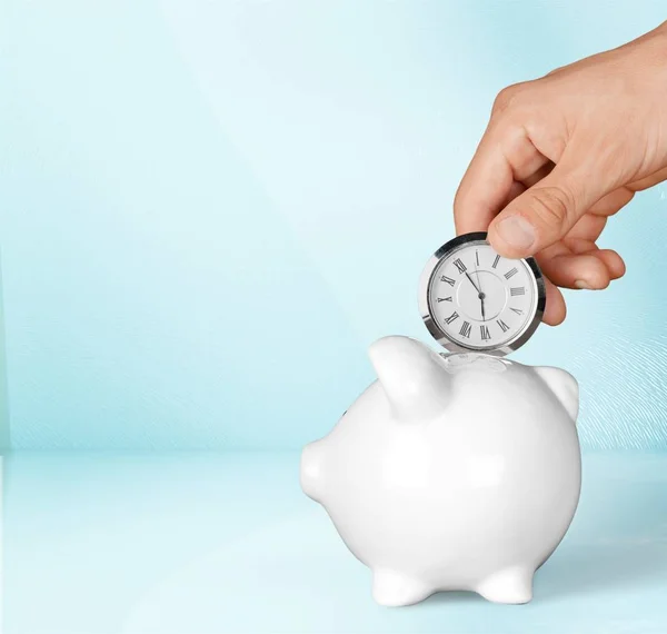 Hand depositing  clock  in piggy bank — Stock Photo, Image