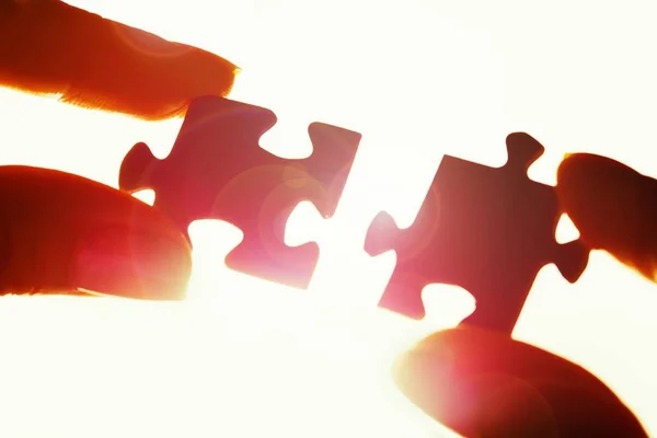 Hands joining puzzle parts — Stock Photo, Image