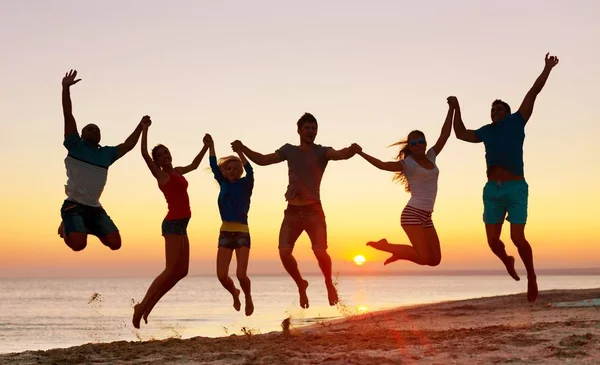 Friends jumping on beach — Zdjęcie stockowe