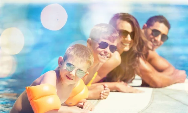 Família feliz brincando na piscina. — Fotografia de Stock