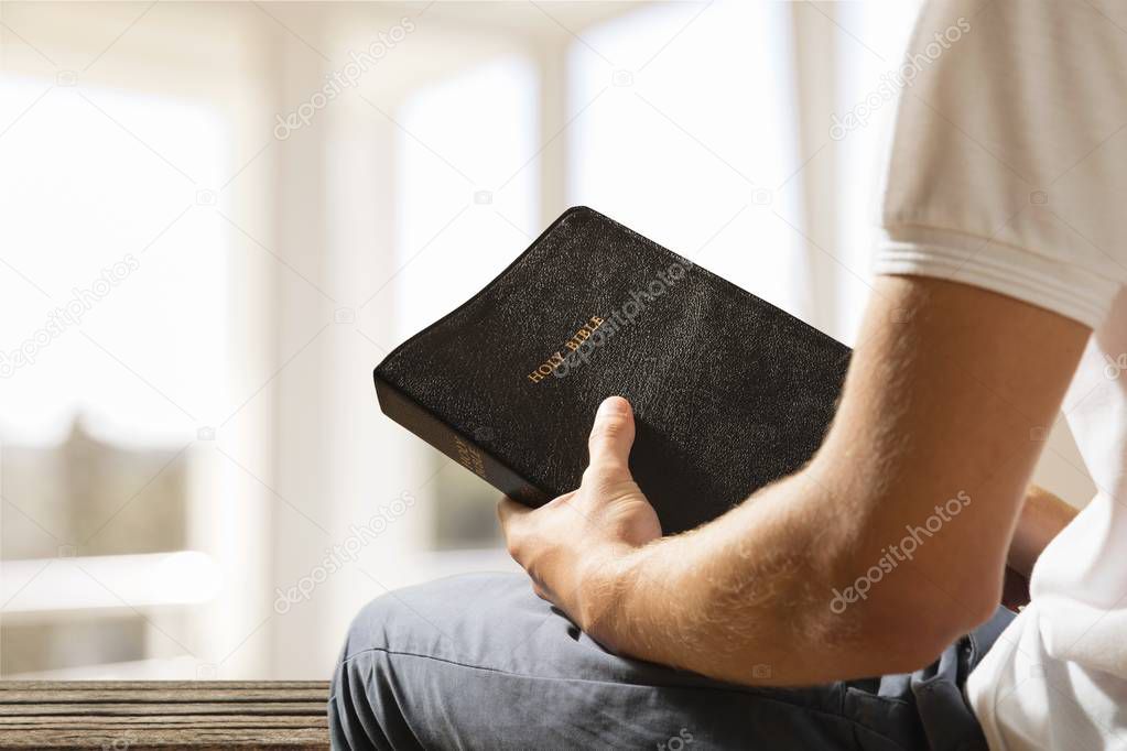 Man holding  bible book 