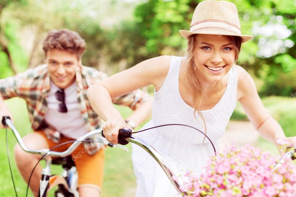 couple cycling through park