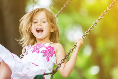 küçük kız salıncakta eğleniyor