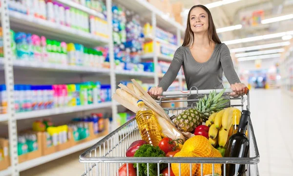 Woman pushing shopping cart — Stock Photo, Image