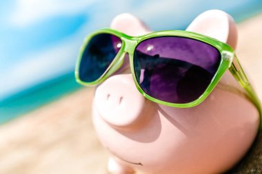 Sahilde güneş gözlüğü ile Piggy banka