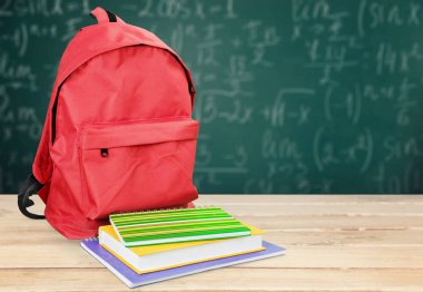 ahşap masa üzerinde kırmızı sırt çantası