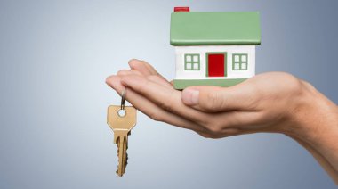 küçük ev modeli tutan el