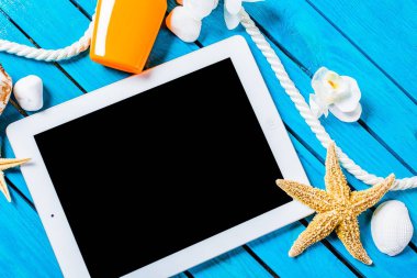 Tablet bilgisayar plaj aksesuarları ve sahilde deniz kabukları