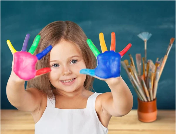 Malá holčička ukazující malované ruce — Stock fotografie