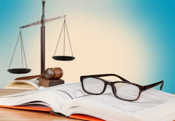 Escalas de justiça e livro com óculos — Fotografia de Stock