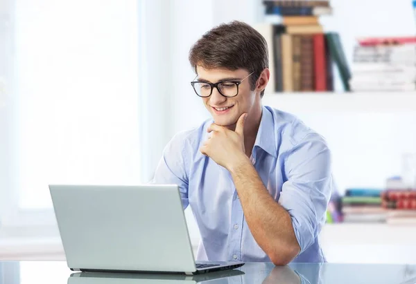Homem bonito em óculos usando laptop — Fotografia de Stock