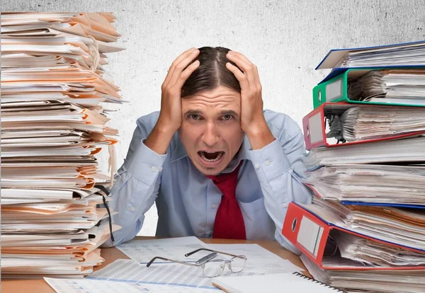 Businessman near heap of papers — Stock Photo, Image