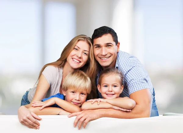 Famiglia sorridente seduta a casa — Foto Stock