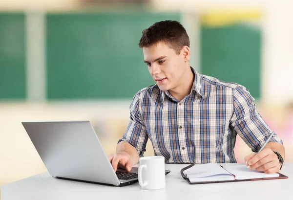 Jovem feliz trabalha em seu laptop — Fotografia de Stock