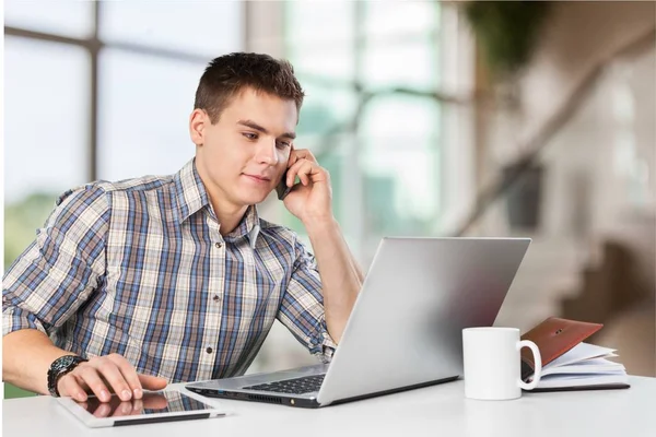 Jovem feliz trabalha em seu laptop — Fotografia de Stock