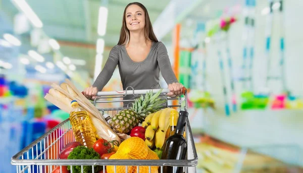 Jonge vrouw winkelen in de supermarkt — Stockfoto